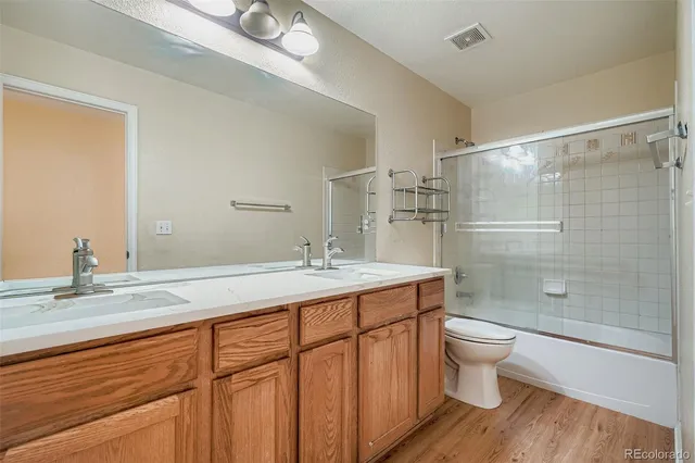a bathroom with a double vanity sink toilet and shower