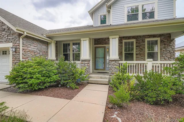 front view of a brick house with potted plants