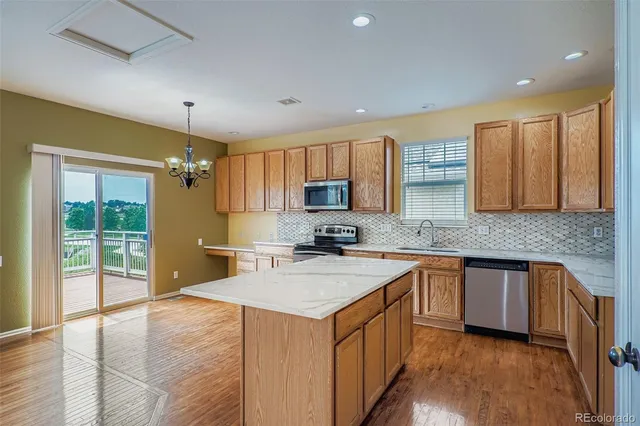 a kitchen with stainless steel appliances granite countertop a sink stove cabinets and wooden floor