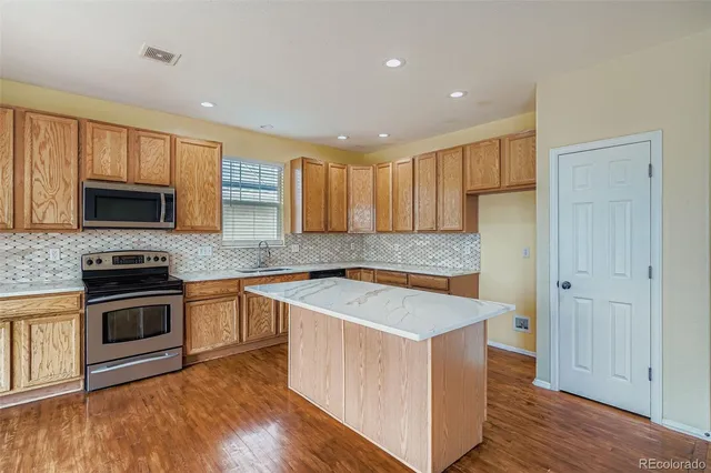 a kitchen with wooden cabinets and stainless steel appliances