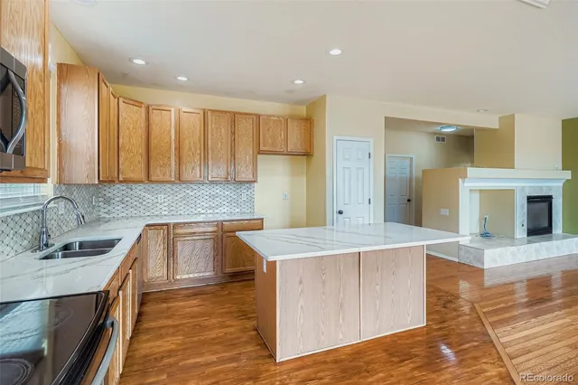 a large kitchen with kitchen island a sink stainless steel appliances and cabinets