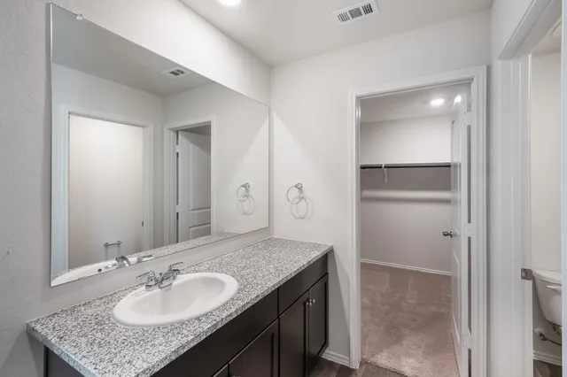 a bathroom with a sink vanity granite and a mirror