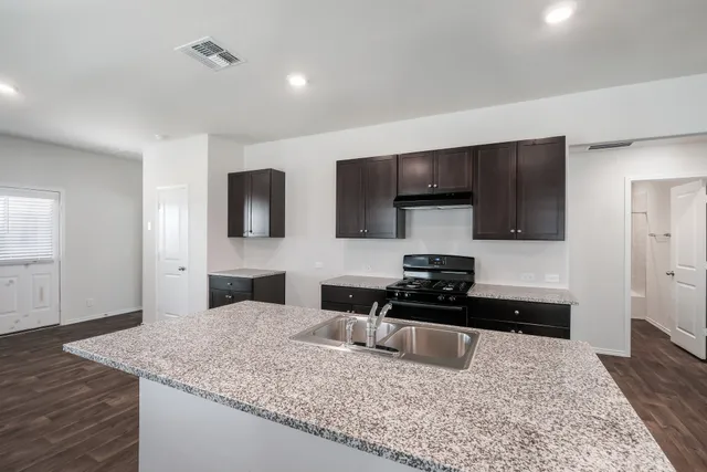 a kitchen with stainless steel appliances granite countertop a sink and a stove