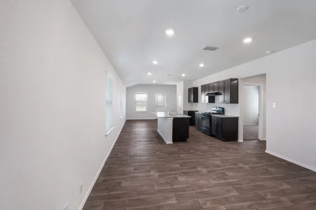 a large white kitchen with a sink and a refrigerator
