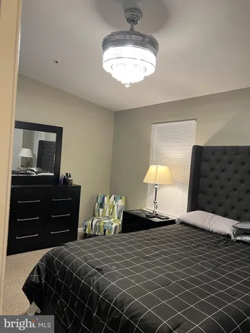 a bedroom with a bed and a lamp on dresser