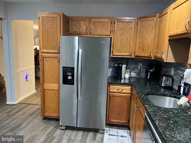 a kitchen with stainless steel appliances granite countertop a refrigerator and a sink