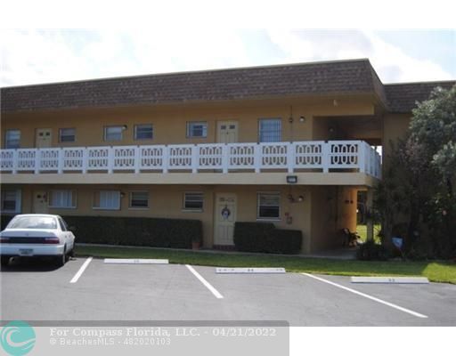 a front view of a building with parking space and a table