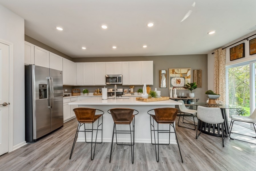 1218 Draper Road McHenry, IL 60050 - Photo 2 of 30 a kitchen with stainless steel appliances granite countertop a dining table chairs refrigerator sink and cabinets