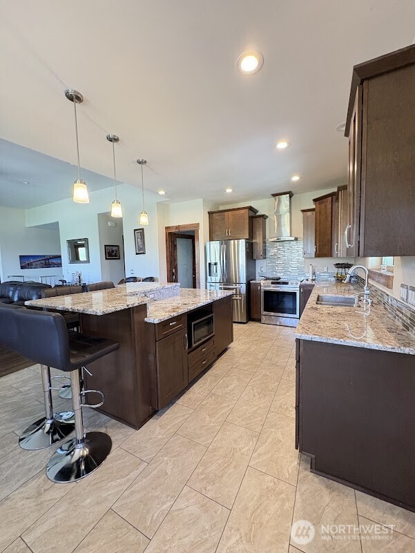 1515 American Fruit Road Wenatchee, WA 98801 - Photo 13 of 35 a kitchen with stainless steel appliances kitchen island granite countertop a sink counter space and cabinets