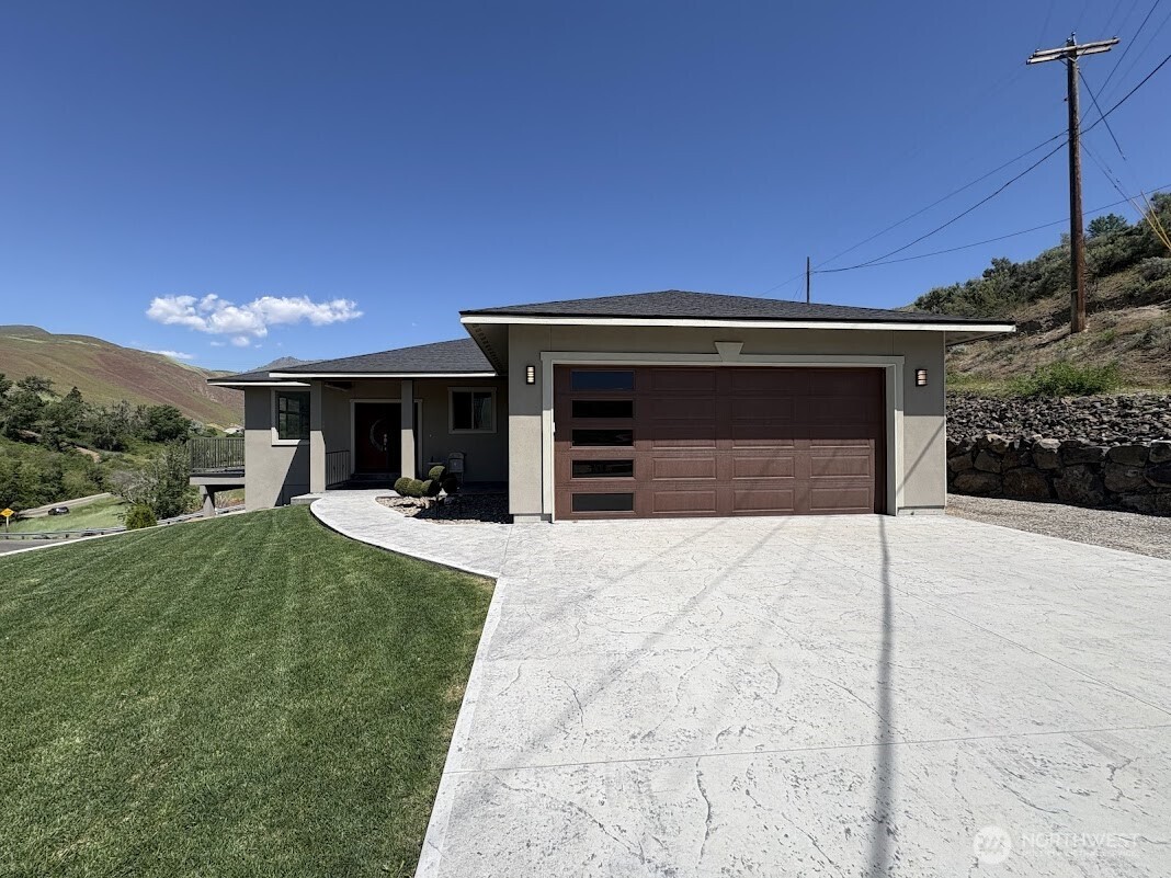 1515 American Fruit Road Wenatchee, WA 98801 - Photo 3 of 35 a front view of a house with a yard and garage