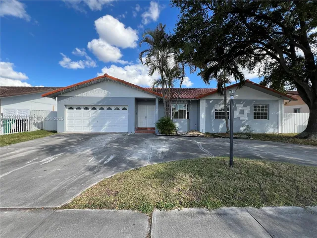 a white house with a tree in front of it