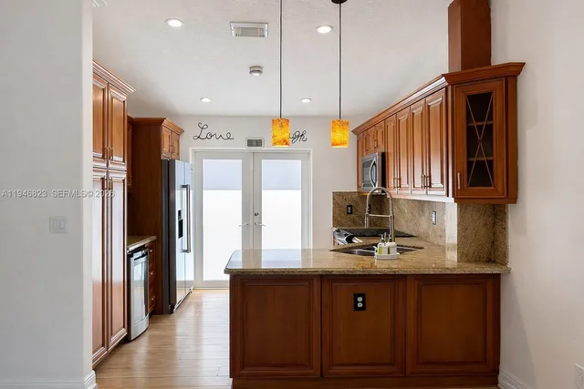 a kitchen with stainless steel appliances granite countertop a refrigerator a sink and a stove