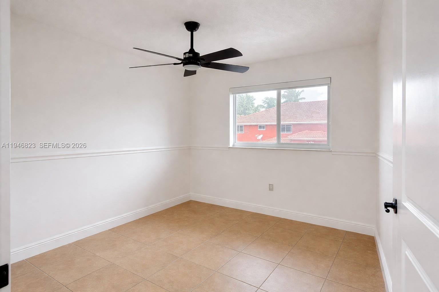 10923 West Okeechobee Road, Unit 201 Hialeah Gardens, FL 33018 - Photo 6 of 13 a view of a room with a window and a ceiling fan