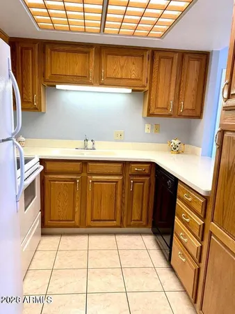 a kitchen with a sink a stove top oven and cabinetry