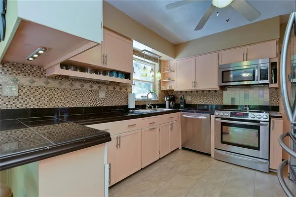 a kitchen with stainless steel appliances granite countertop a refrigerator and a sink