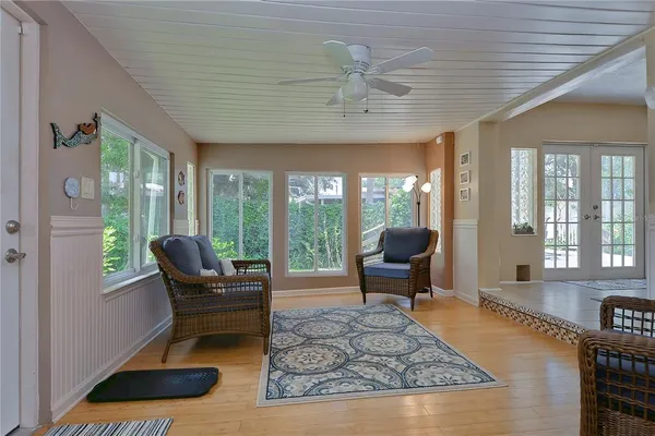 a living room with furniture a piano and a floor to ceiling window