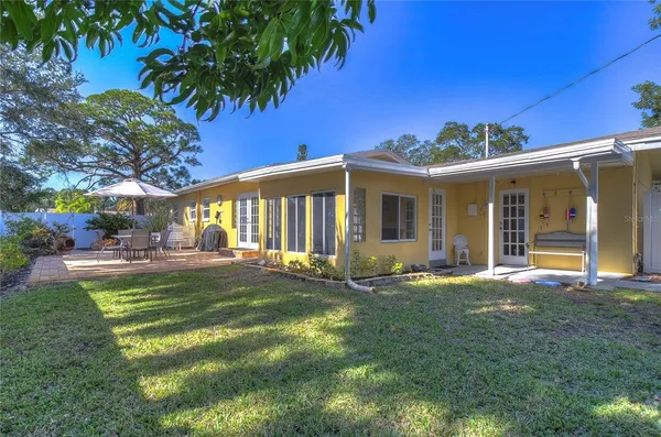 a view of a house with backyard and sitting area