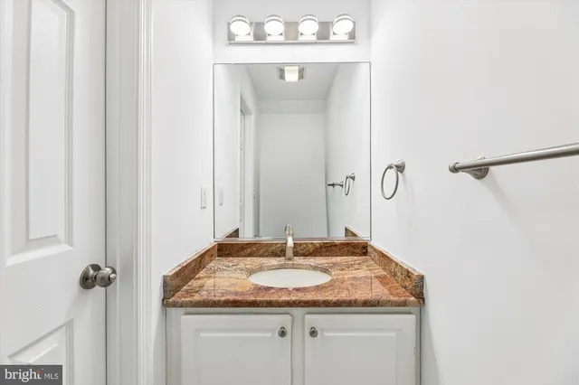 a bathroom with a granite countertop sink and a mirror