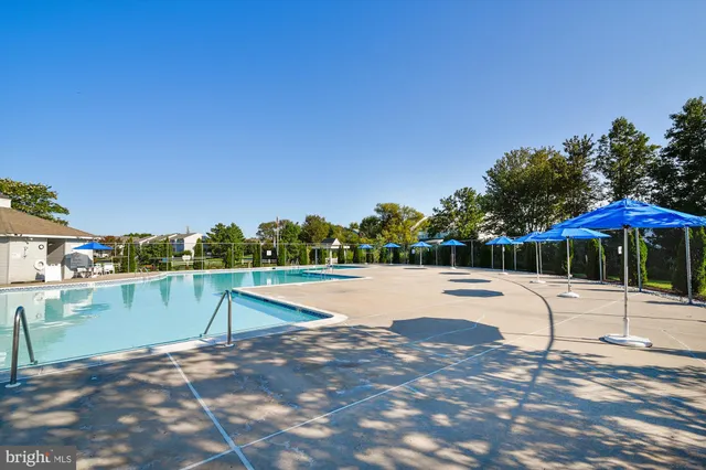 a swimming pool with an outdoor space and seating area