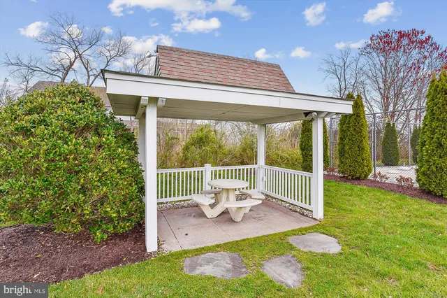 a porch with a table and chairs and potted plants