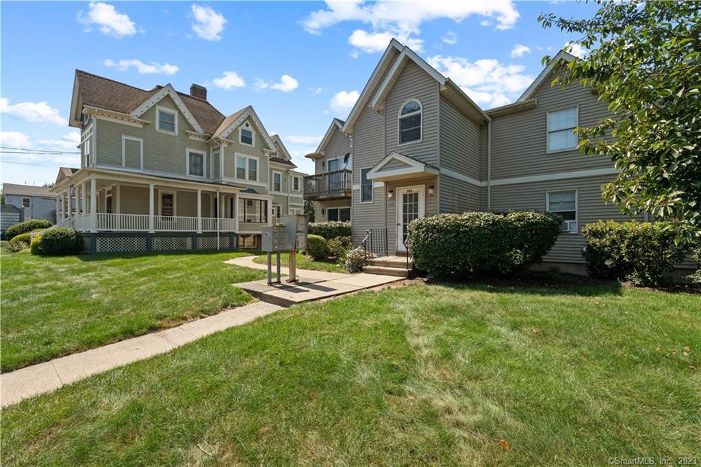 666 Broad Street, Unit 7 Meriden, CT 06450 - Photo 1 of 1 a front view of a house with a yard and trees