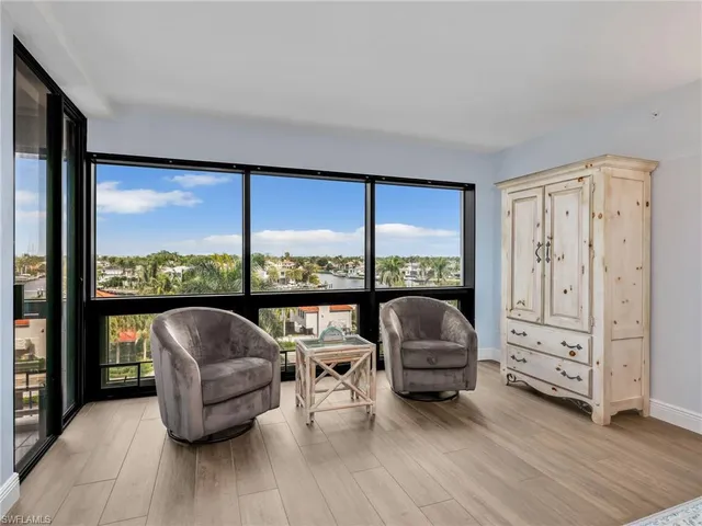 a dining room with furniture and a floor to ceiling window