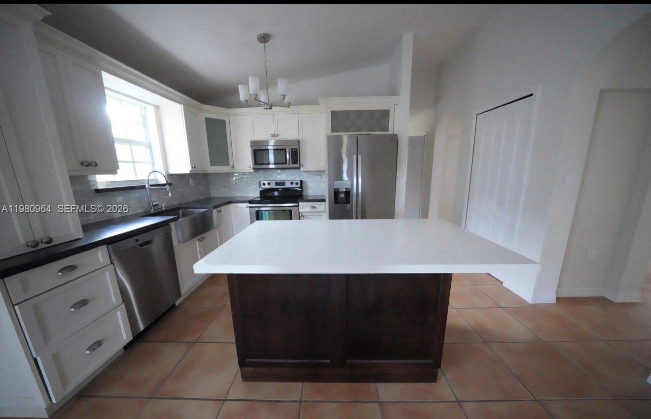 9921 Southwest 164th Court Miami, FL 33196 - Photo 5 of 20 a kitchen with stainless steel appliances a kitchen island a stove a refrigerator and a sink