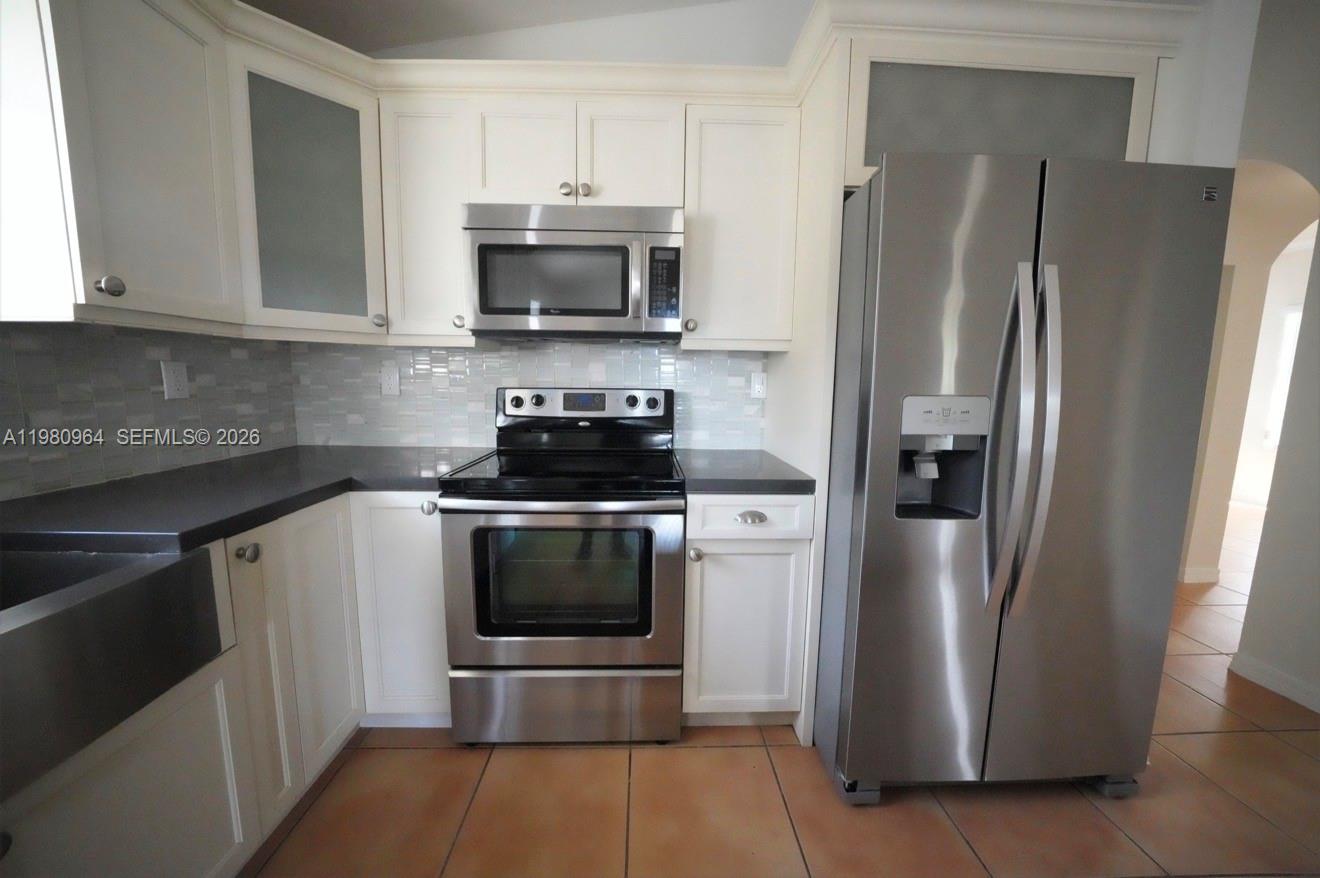 9921 Southwest 164th Court Miami, FL 33196 - Photo 6 of 20 a kitchen with stainless steel appliances a refrigerator stove and microwave