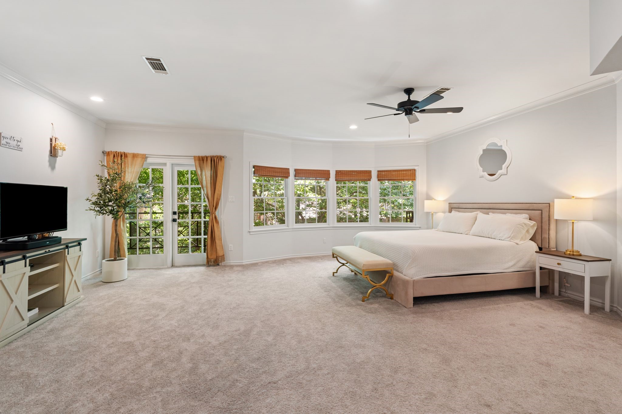 201 Vanderpool Lane, Unit 137 Houston, TX 77024 - Photo 19 of 42 A true retreat tucked into the trees. Located on the 2nd floor, this oversized primary suite feels like a private treehouse with a wall of windows overlooking the lush greenery beyond. Newer plush carpeting with vinyl hardwoods underneath. French doors open to a secluded balcony—perfect for slow mornings with coffee or winding down at night.