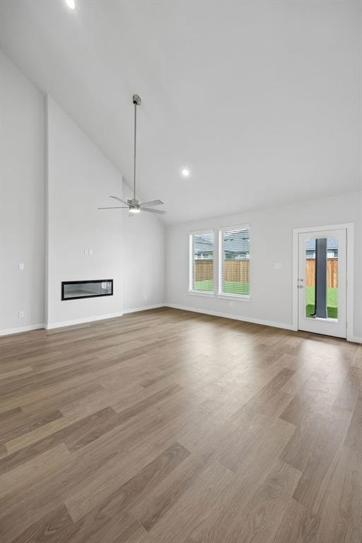 1460 Companero Street Haslet, TX 76052 - Photo 11 of 35 an empty room with wooden floor ceiling fan and windows