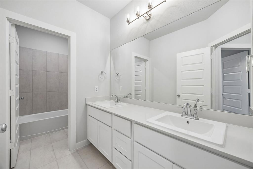1460 Companero Street Haslet, TX 76052 - Photo 28 of 35 a bathroom with a sink double vanity granite tub and a mirror