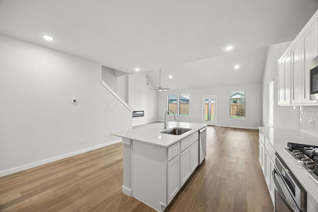 1460 Companero Street Haslet, TX 76052 - Photo 34 of 35 a kitchen with a sink stove and wooden floor
