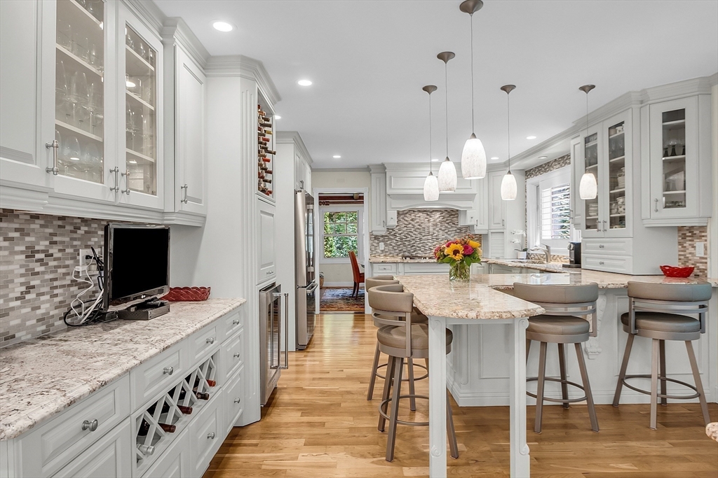 595 Salisbury Street Worcester, MA 01609 - Photo 13 of 41 a kitchen with stainless steel appliances kitchen island granite countertop a stove top oven a sink a dining table and chairs with wooden floor