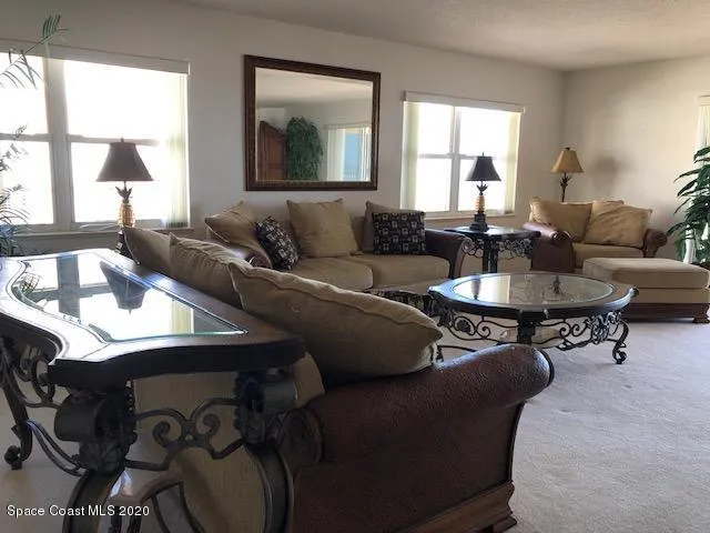 a living room with furniture lamp and a large window