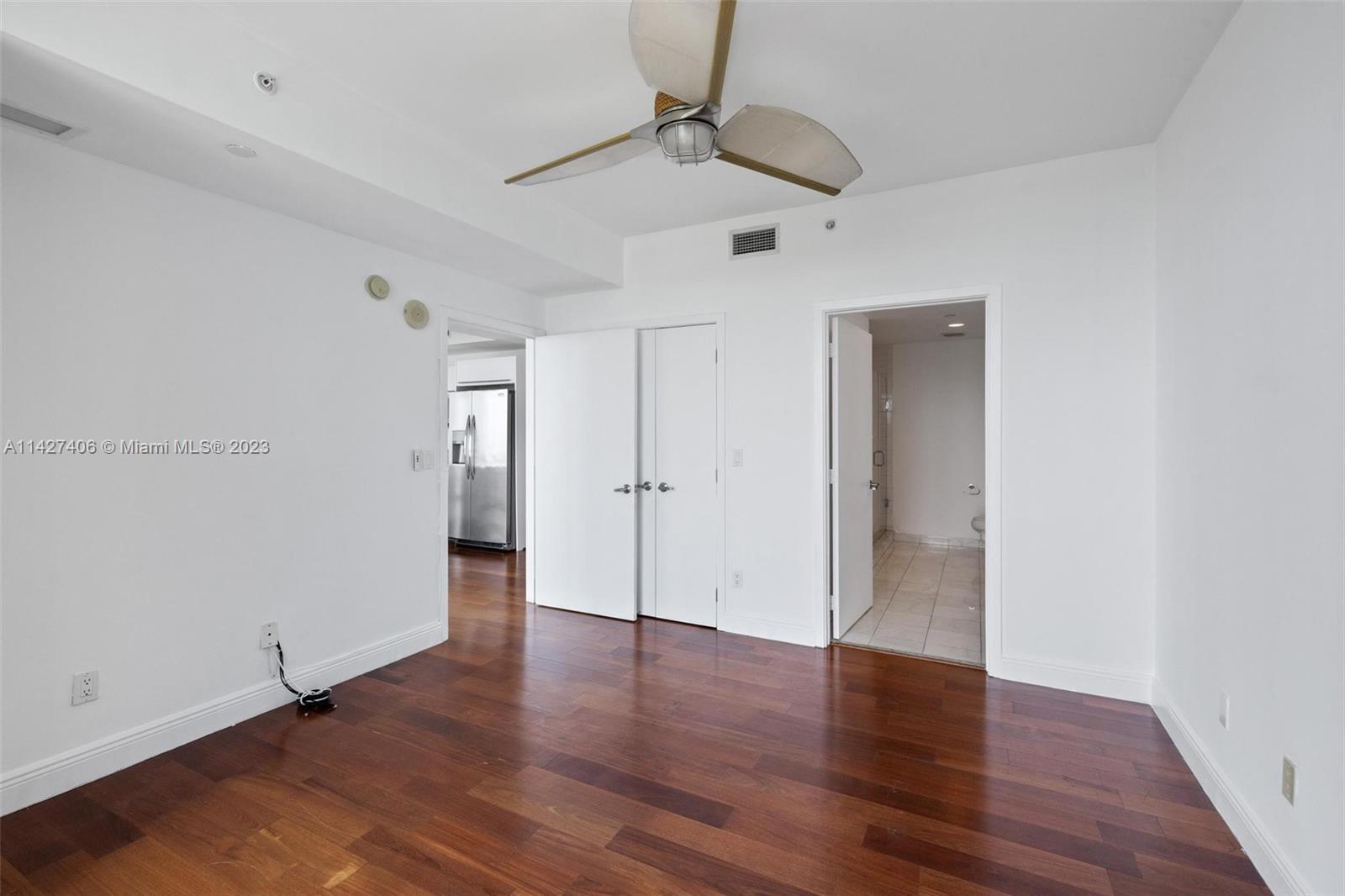 888 Biscayne Boulevard, Unit 2208 Miami, FL 33132 - Photo 11 of 20 an empty room with wooden floor ceiling fan and windows