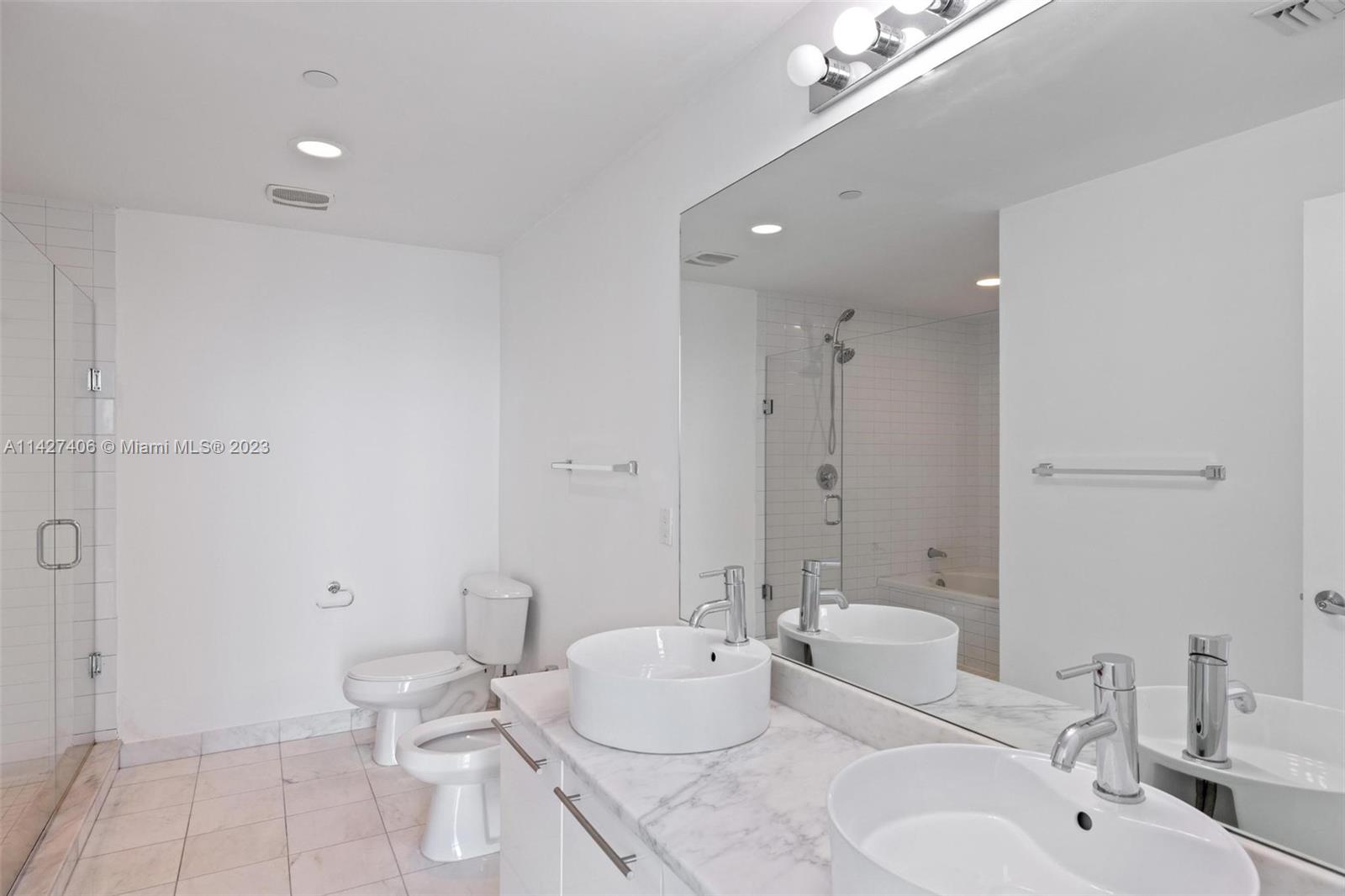 888 Biscayne Boulevard, Unit 2208 Miami, FL 33132 - Photo 14 of 20 a bathroom with a double vanity sink toilet and shower