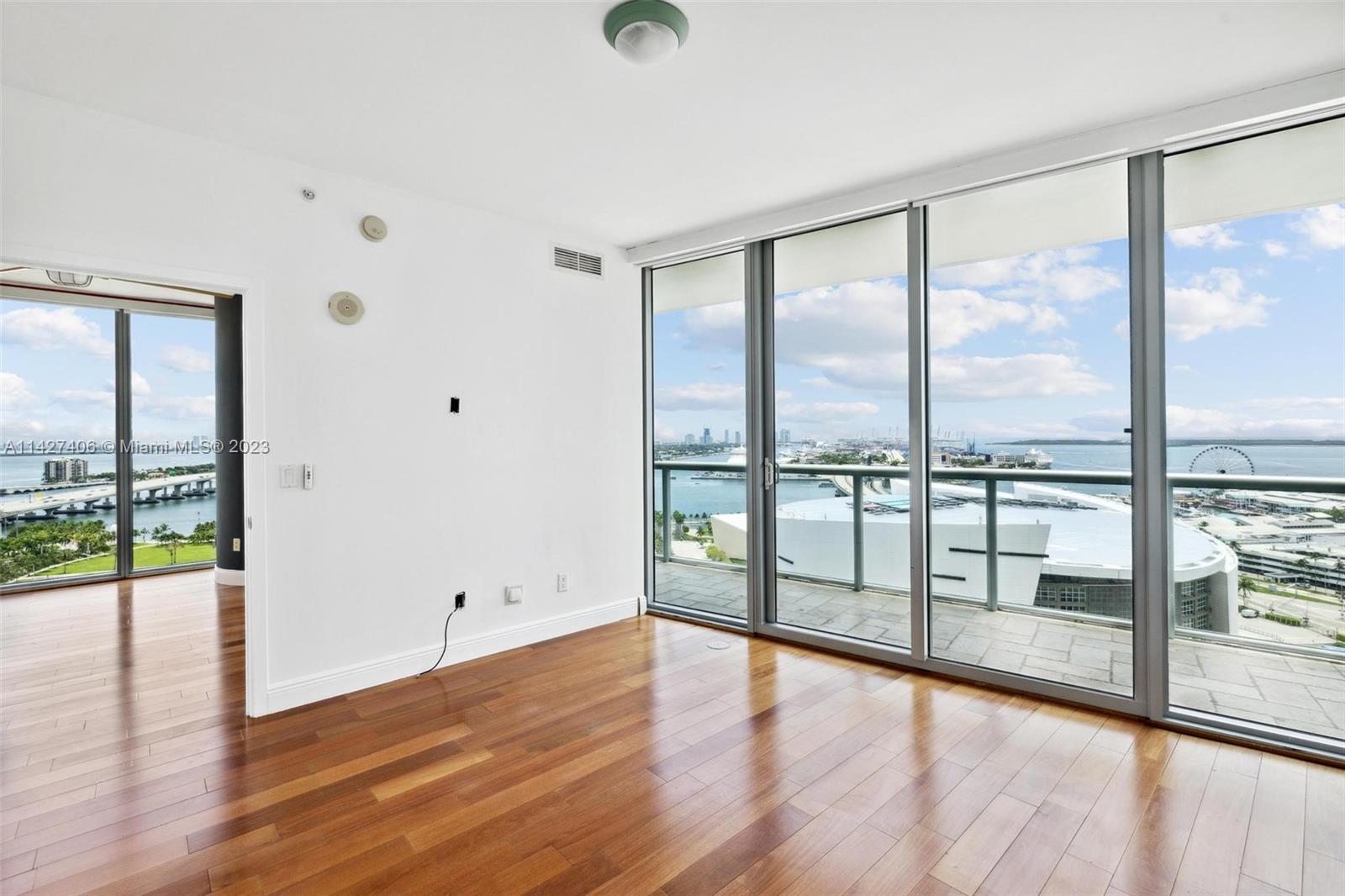 888 Biscayne Boulevard, Unit 2208 Miami, FL 33132 - Photo 15 of 20 a view of an empty room with wooden floor and a large window
