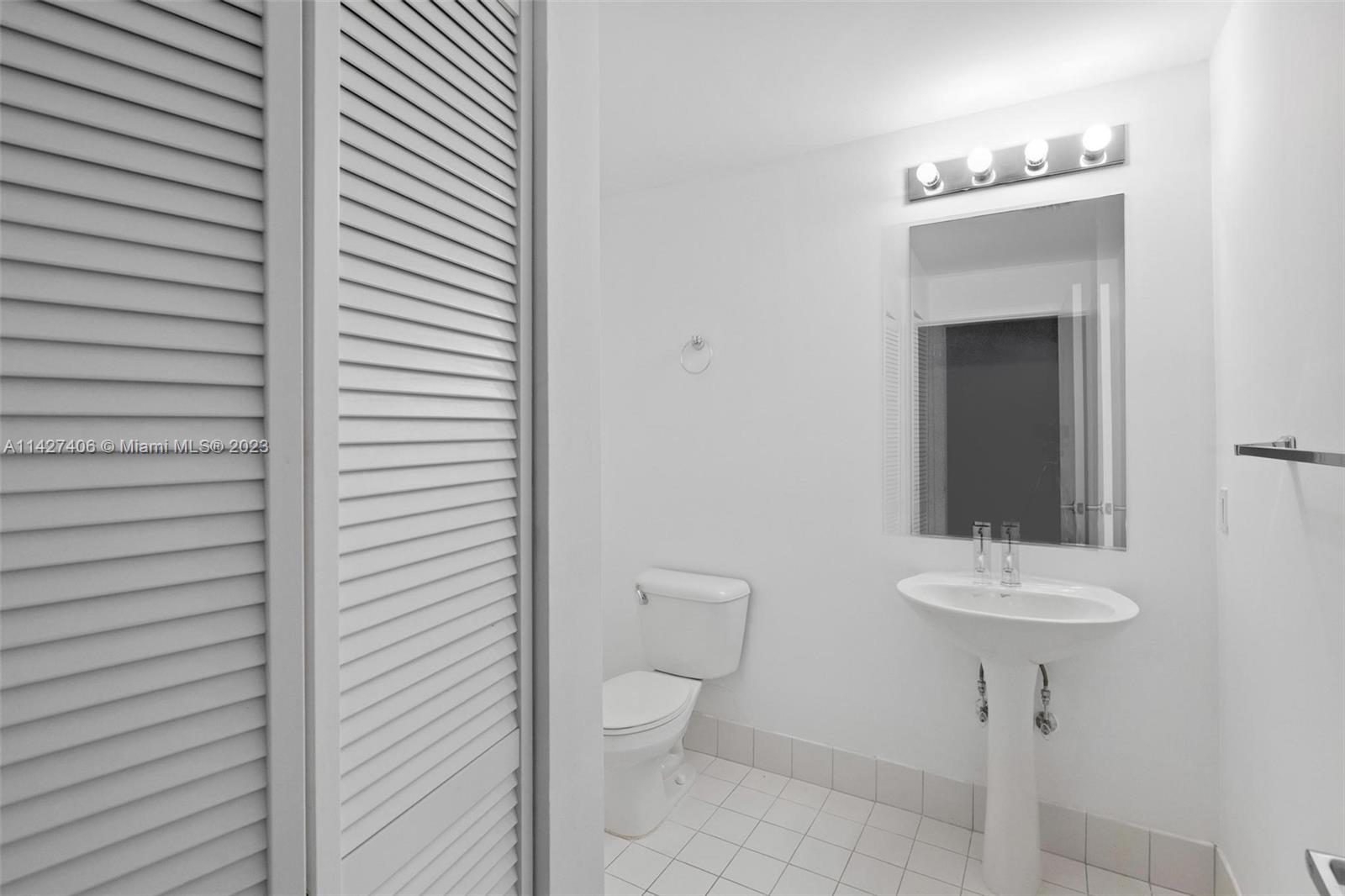 888 Biscayne Boulevard, Unit 2208 Miami, FL 33132 - Photo 19 of 20 a bathroom with a toilet a sink and a mirror