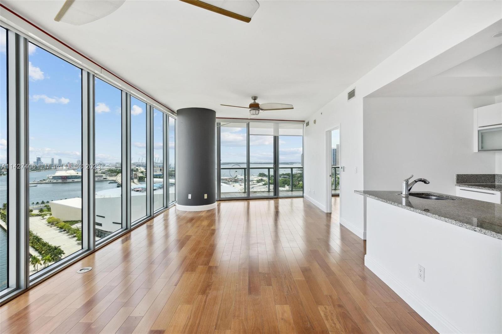 888 Biscayne Boulevard, Unit 2208 Miami, FL 33132 - Photo 2 of 20 a large living room with a large window and wooden floor