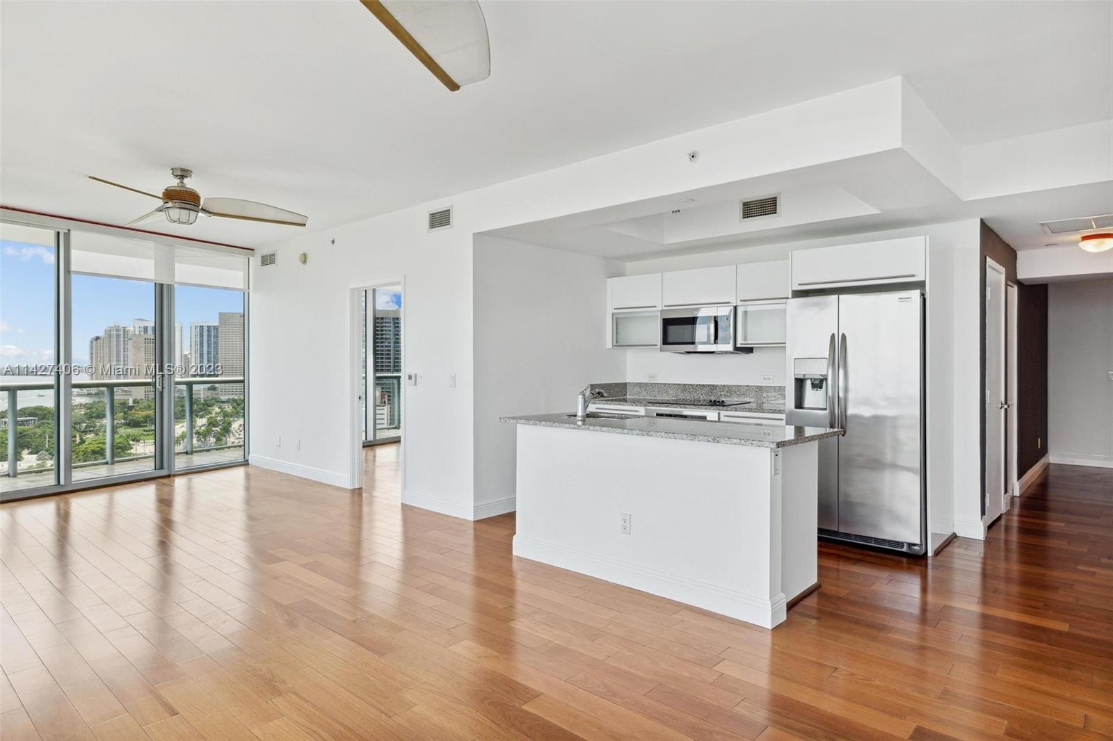 888 Biscayne Boulevard, Unit 2208 Miami, FL 33132 - Photo 6 of 20 a view of kitchen with stainless steel appliances wooden floor and window