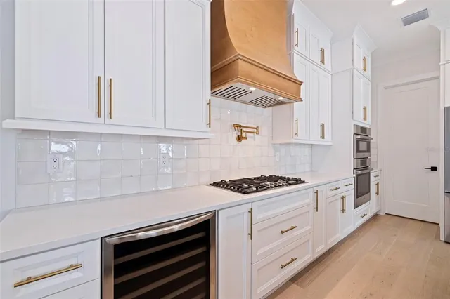 a kitchen with white cabinets and appliances