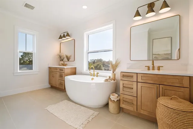 a bathroom with a sink mirror bathtub and next to a window