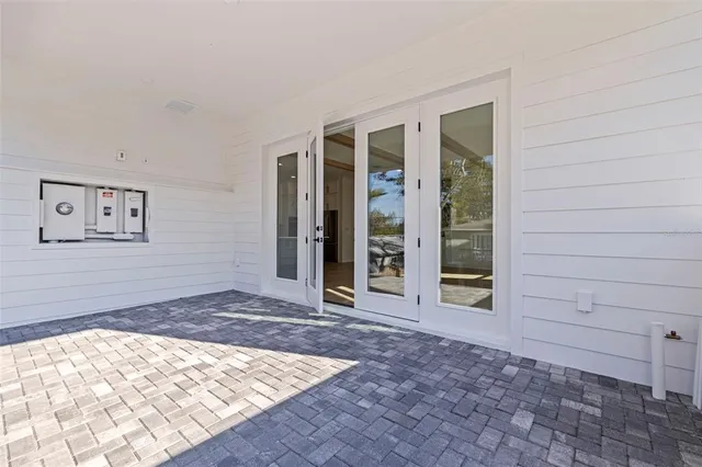 a view of an empty room with wooden floor and a rug