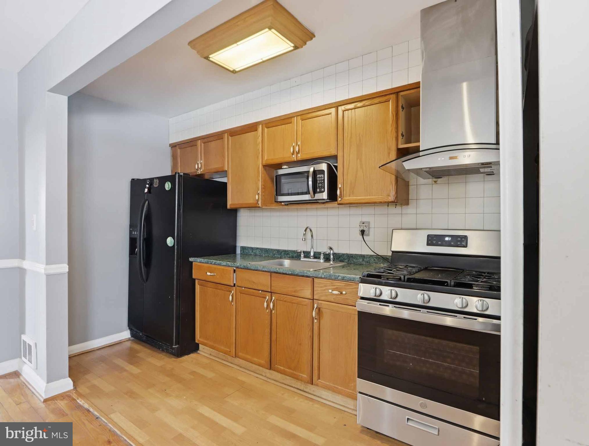 6832 Broening Road Baltimore, MD 21222 - Photo 16 of 34 a kitchen with stainless steel appliances granite countertop a stove a sink and a refrigerator