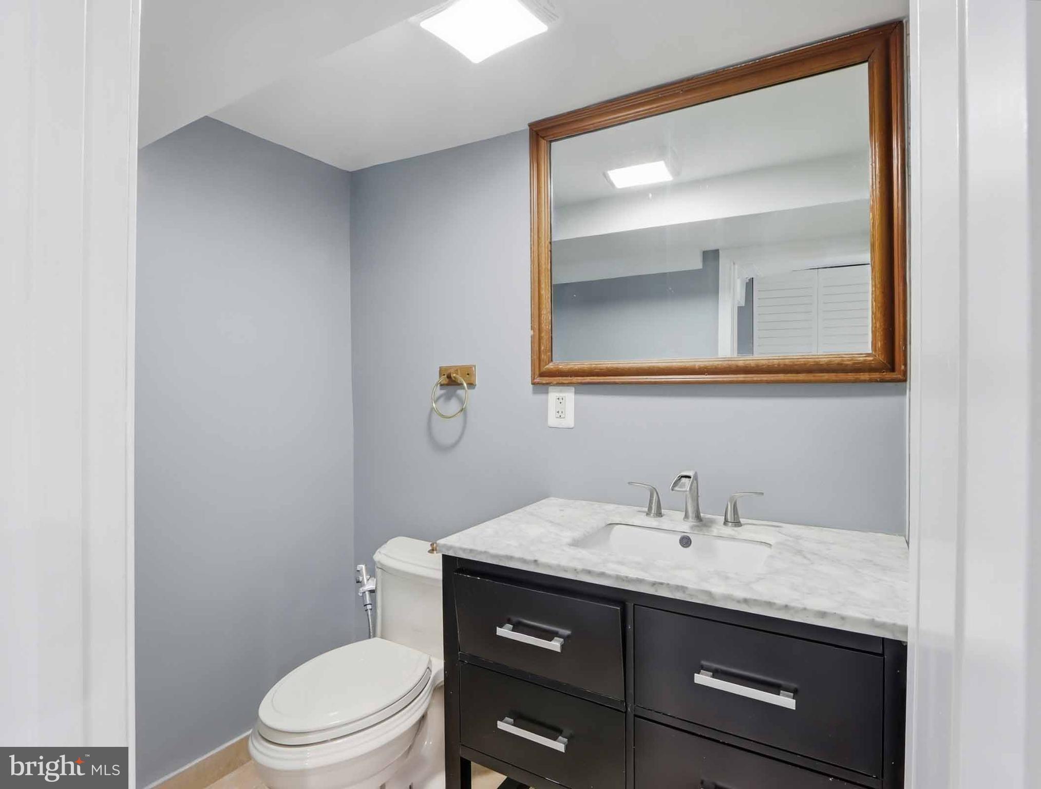 6832 Broening Road Baltimore, MD 21222 - Photo 20 of 34 a bathroom with a granite countertop toilet sink and mirror