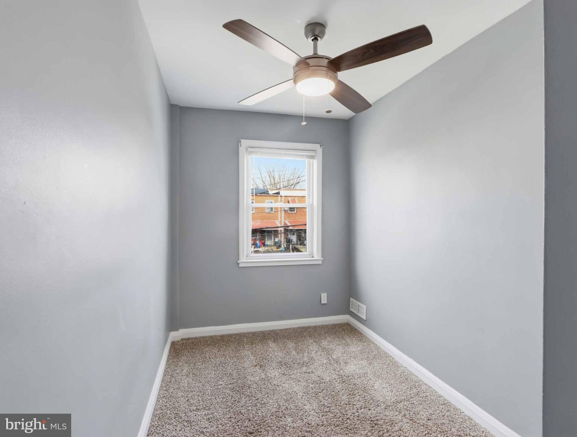 6832 Broening Road Baltimore, MD 21222 - Photo 25 of 34 an empty room with a window and a ceiling fan