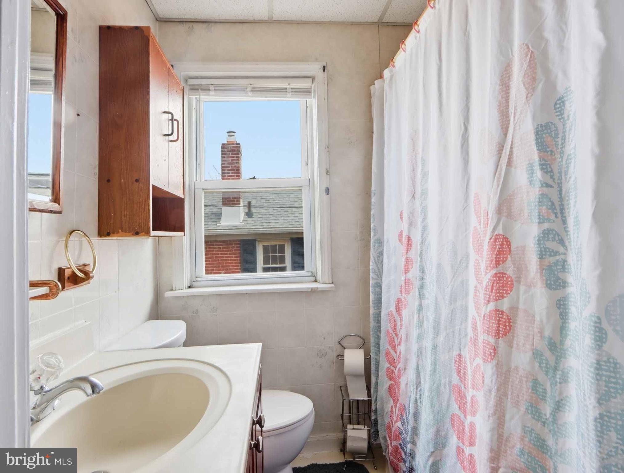 6832 Broening Road Baltimore, MD 21222 - Photo 29 of 34 a bathroom with a sink toilet and shower curtain