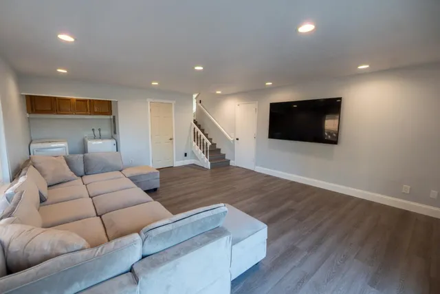a living room with furniture and a wooden floor