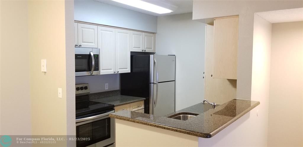 2846 South University Drive, Unit 4205 Davie, FL 33328 - Photo 3 of 9 a kitchen with stainless steel appliances granite countertop a refrigerator and a stove
