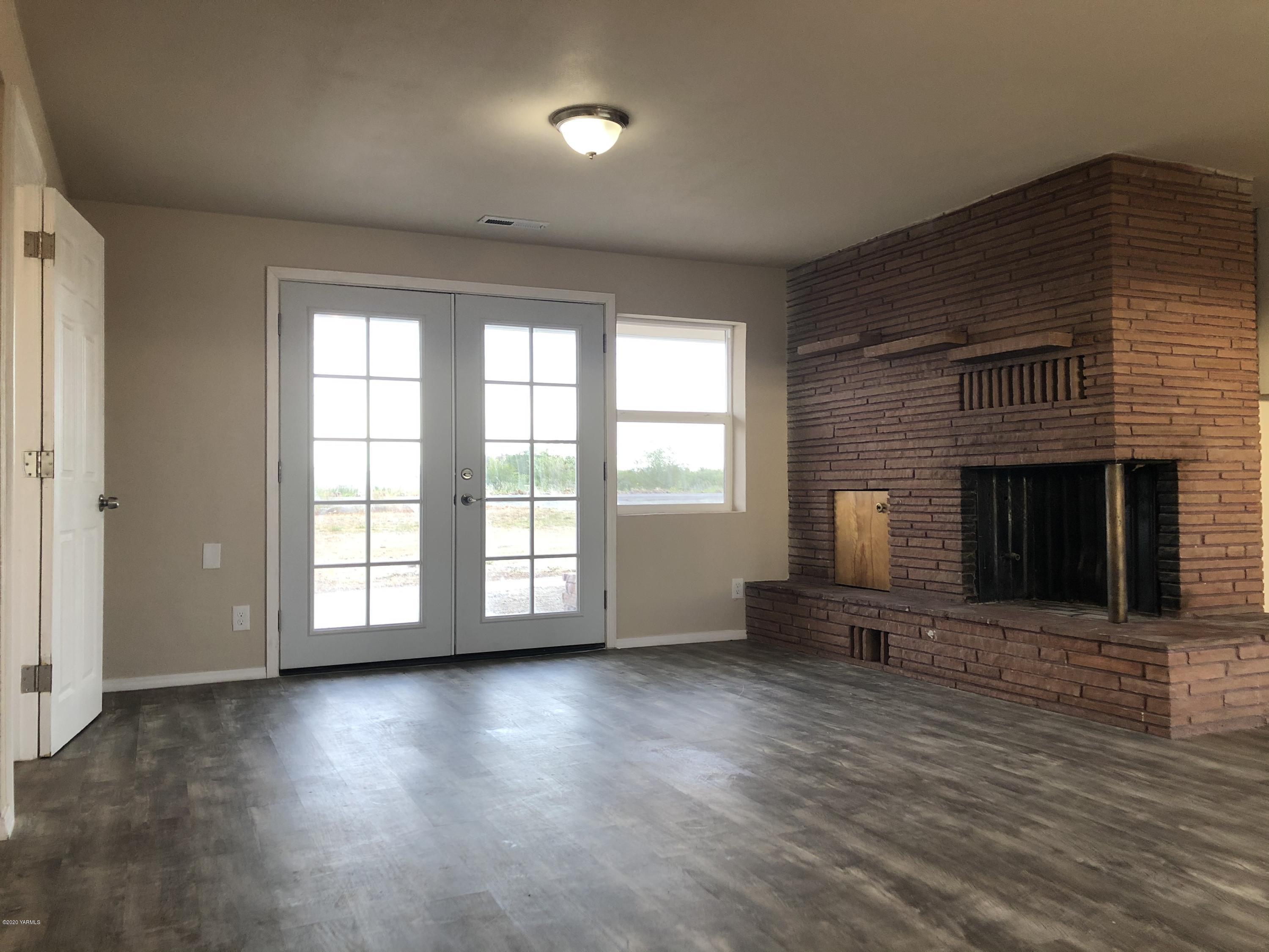 4950 Lateral A Road Wapato, WA 98951 - Photo 16 of 31 an empty room with wooden floor and a fireplace